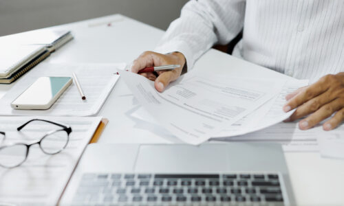 person reviewing documents thoughtful decision moment pen in hand