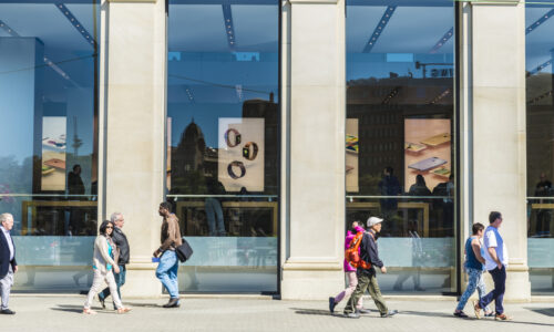 people walking past a storefront window ignoring the business